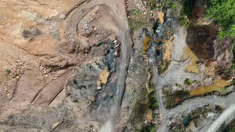 Aerial view of a quarry lake surrounded by lush greenery and mountains Stock Footage 334646922