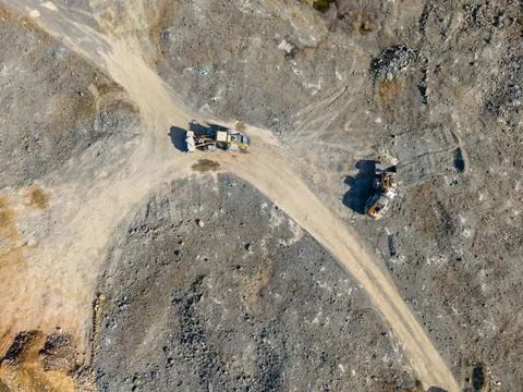 Aerial view of a quarry with two work vehicles on winding dirt roads among ex Fotos de archivo