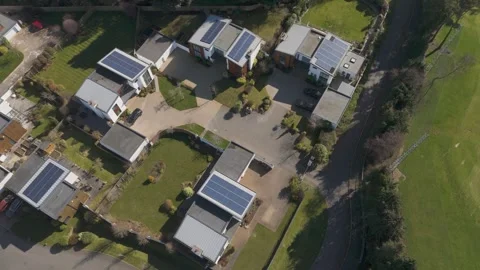 Aerial view of quiet cul-de-sac of angular white houses, rooftop solar panels Video stock 310599894