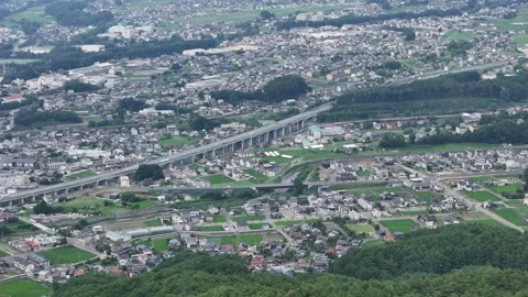 Aerial view of a quiet town surrounded by green hills and fields Stock Footage 340909501