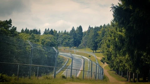 Aerial view of racetrack surrounded by forest. Looking through fence Stock Footage 111422338