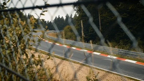Aerial view of racetrack surrounded by forest. Looking through fence Stock Footage 111424766
