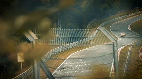 Aerial view of racetrack surrounded by forest. Looking through fence Stock Footage 111425198