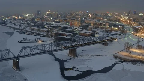 Aerial view. Railway bridge with train over frozen river of big industrial city. Stock Footage 102324746