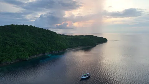 Aerial View of Rain Clouds and Tropical Island at Sunrise Stock Footage 258504109