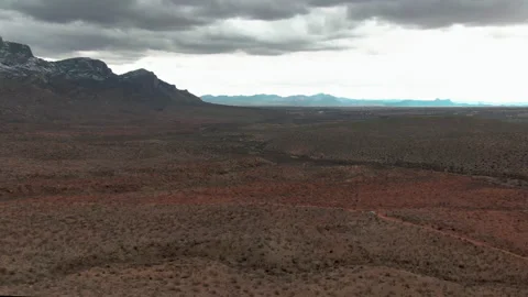 Aerial View of Rain Clouds over Desert Mountains with Snow 4K Stock Footage 153877860
