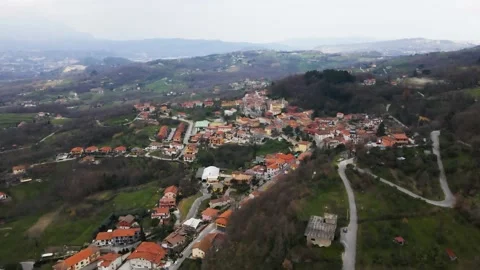 Aerial view of a raised square in a small village with a church and trees Stock Footage 149997236