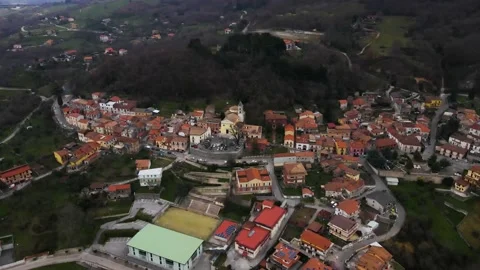 Aerial view of a raised square in a small village with a church and trees Stock Footage 149997268