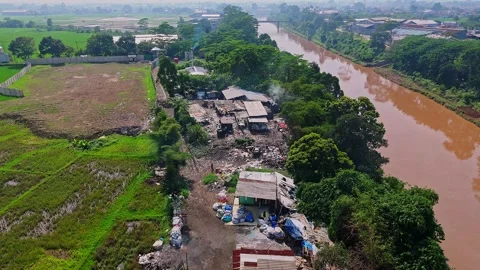 Aerial view of recycling facility and waste management area near river and Stock Footage 333608096