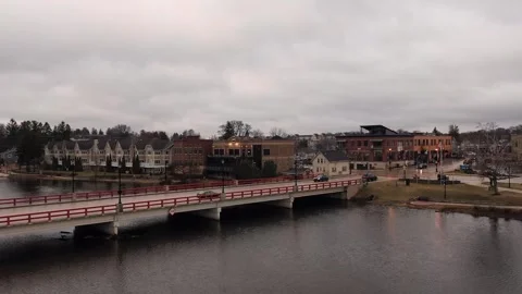 Aerial View of Red Bridge Over River in Small Town, Overcast Day Stock Footage 333398194