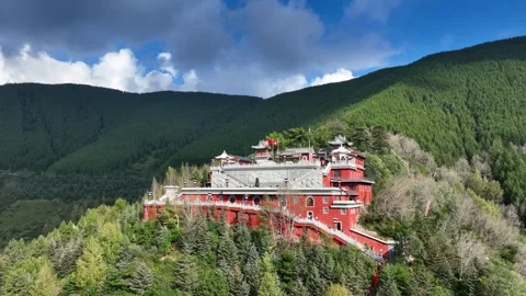 Aerial View of Red Buddhist Temple Complex Nestled in Lush Green Mountain Forest Stock Footage 342243633