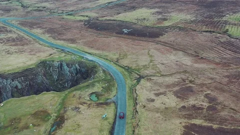 Aerial view of red car moving on beautiful curved costal road Stock Footage 101540748