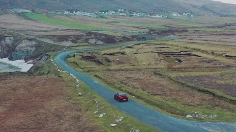 Aerial view of red car moving on beautiful curved costal road Stock Footage 101541289