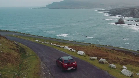 Aerial view of red car moving on beautiful curved costal road Stock Footage 101541533