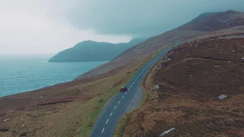 Aerial view of red car moving on beautiful curved costal road Stock Footage 101541769