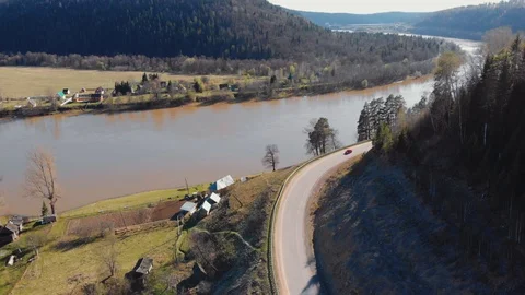 Aerial view of red car moving along mountain serpentine along river Stock Footage 106275953