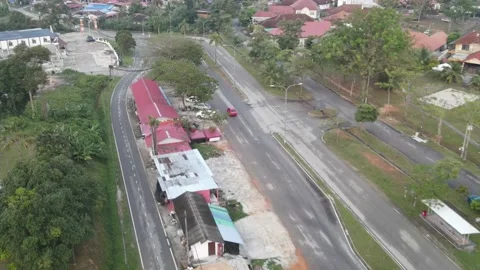 Aerial view of red Car moving on the road in Desa Pinggiran Putra Stock Footage 150747561