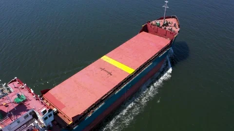 Aerial view of red cargo grain ship floats on the calm sea on warm sunny day Stock Footage 176679141