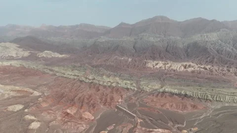 Aerial view of red desert ridges and layered badlands in Xinjiang China Stock Footage 337757033