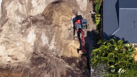 Aerial View of Red Excavator Digging at Residential Construction Site 스톡 동영상 339122344