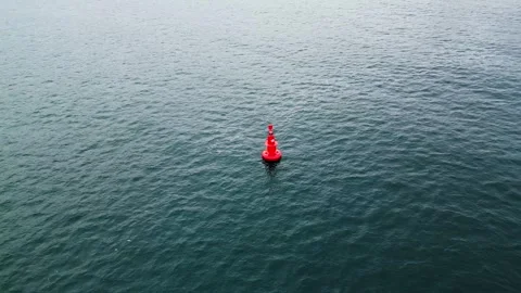Aerial view of a red navigation buoy floating in the calm waters of the Sea. Video stock 297780959