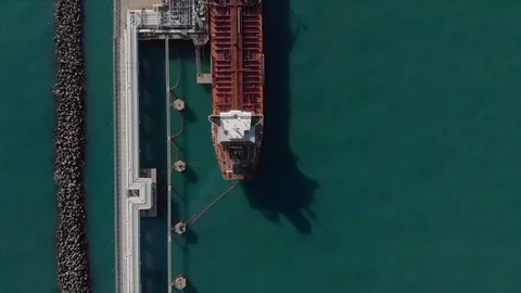 Aerial view of a red oil tanker moored at the jetty of the oil terminal. Stock Footage 103118564