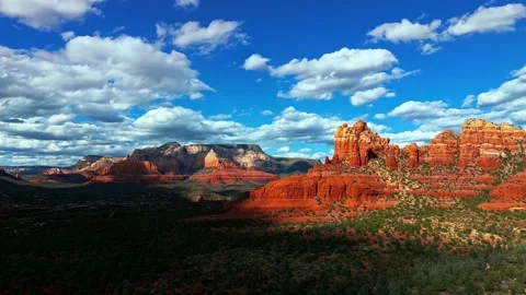 Aerial view of red rock formations under blue sky with white clouds. Stock Footage 341070682