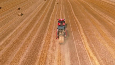 Aerial view of red square baler baling straw on farmland after harvest Stock Footage 340530698