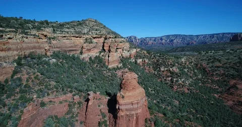 An aerial view of red standstone formations in Sedona, Arizona on a sunny day Stock Footage 112300005