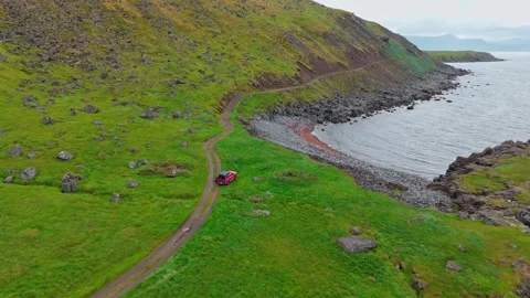 Aerial View Of Red SUV Driving On Svalvogaviti Road In Iceland West Fjords Stock Footage 340073875