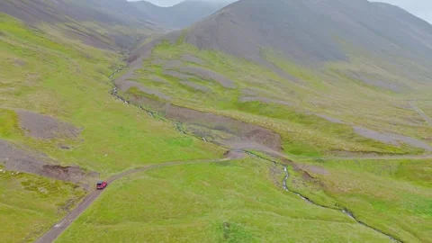 Aerial View Of Red SUV Driving Through Iceland West Fjords Mountain Pass Stock Footage 340899440