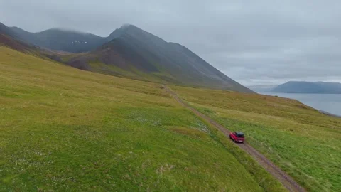 Aerial View Of Red SUV Driving On Svalvogaviti Road In Iceland West Fjords Stock Footage 340901015
