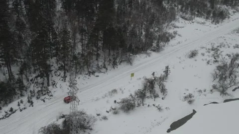 Aerial view of red SUV driving through snowstorm in Tibet Video stock 345169384