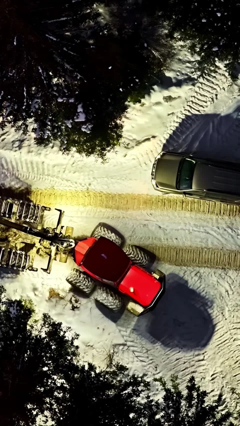 Aerial view of a red tractor working in a snowy forest, Latvia. Stock Footage 339802518