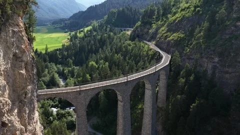 Aerial view of red train crossing the landwasser viaduct in switzerland Video stock 318364419
