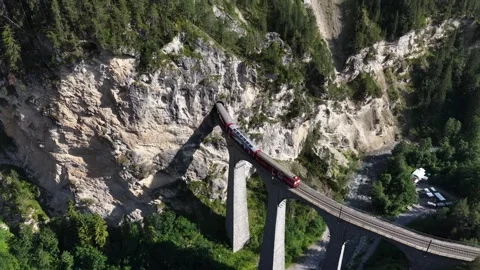 Aerial view of a red train crossing the landwasser viaduct Stock Footage 318365903