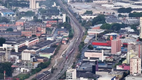 Aerial View of Red Train on Tracks Through São Paulo Industrial Zone 動画素材 343996743