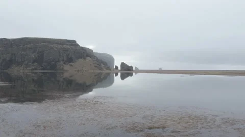 Aerial view, reflection on black sand beach behind Dyrholaey Video stock 239059915