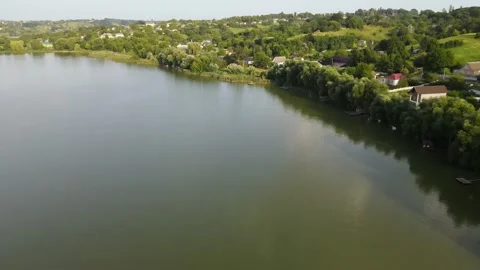 Aerial view of Reflection Lake in Valley near to Hills, with Village Stock Footage 162621889
