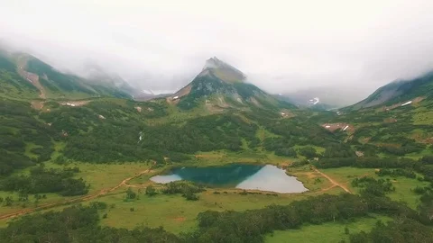Aerial View. Reflections of the mountain in a lake. Close approach to waterfall Stock Footage 73139750