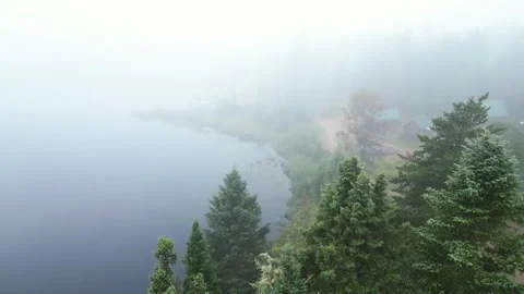 Aerial View of a Remote Lakeside Camp with Cabins in Morning Fog Vidéo 336947821