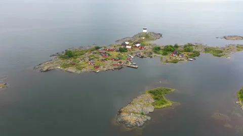 Aerial view of remote lighthouse and village on an island Stock Footage 256209546