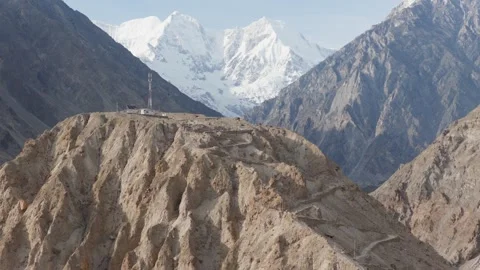Aerial view of a remote mountain peak in Pakistan, featuring a winding road and 스톡 동영상 314457644