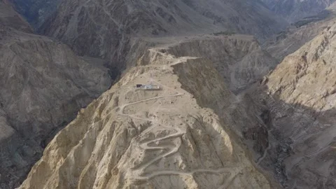 Aerial View of a Remote Mountain Peak in Pakistan, Featuring a Winding Dirt Road 스톡 동영상 314458751