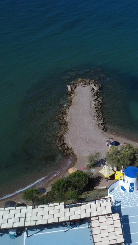 Aerial view of a remote sandy beach with a windmill on a Greek island Stock Footage 344093688