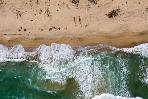 Aerial view of a remote sandy beach and sea waves Stock Photos