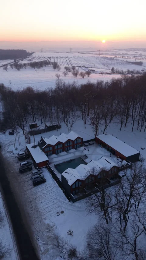 Aerial view of resort complex surrounded by snowy landscape at sunrise Stock Footage 345898415