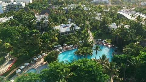 Aerial view of a resort swimming pool at sunset in Impressive Punta Cana Stock Footage 308334096