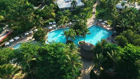 Aerial view of a resort swimming pool at sunset in Impressive Punta Cana Stock Footage 308334957
