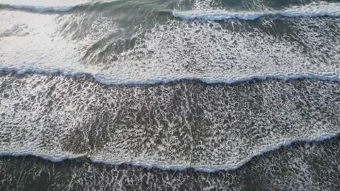 Aerial view of rhythmic ocean waves rolling onto a sandy beach in Huizhou Video stock 347040704